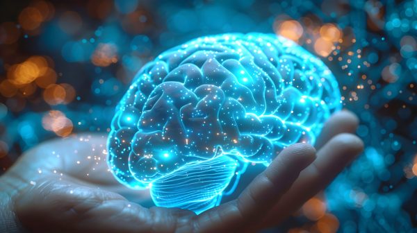 Human brain in hand with emphasis on neurotransmitters, dopamine receptors on dark background with neon lights.